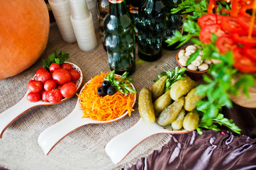 Close-up photo of sour and salty snacks on the wedding banquet along with bottles of beer.