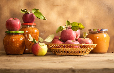 Jam made from apples in glass jars, apples in a wicker basket