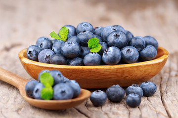 Blueberries in a wood bowl on a wooden table, Healthy eating and nutrition concept