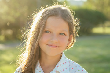 beautiful little girl (daughter) smile long hair in the park summer trip. healthy women concept