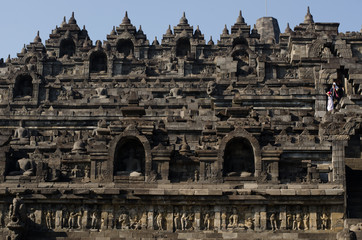 Fototapeta premium Borobudur temple and bell-enshrined Buddhas looking over the jungle and mountains of Java, Indonesia
