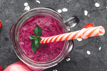 Fresh, cold smoothies of blueberries with berries and mint leaves on a dark background. Healthy diet. Summer