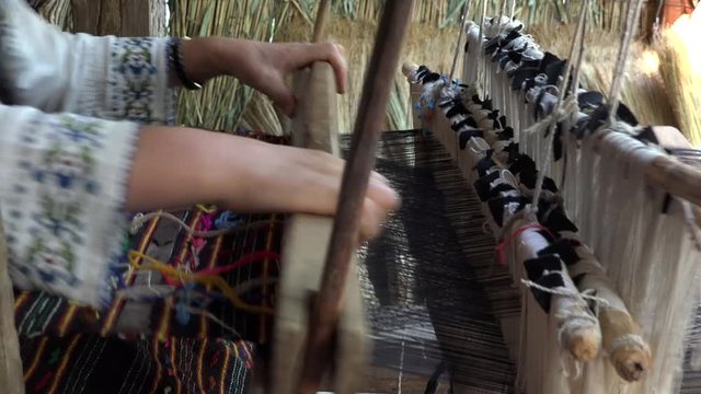 Traditional handmade art, hands working at wooden rustic loom, good skill