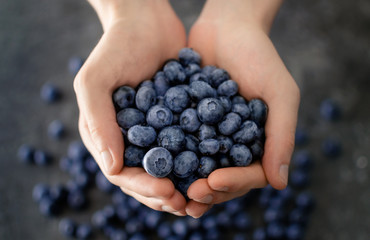 Man’s hands holding fresh ripe blueberries, detailed close up. Savoring the harvest of summer...