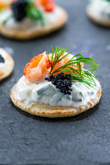 Cocktail blinis with crayfish, caviar and sour cream - gourmet party food idea