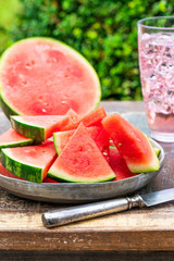 Slices of sweet, refreshing watermelon on a garden table. Summer outdoor eating.