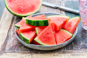 Slices of sweet, refreshing watermelon on a garden table. Summer outdoor eating.