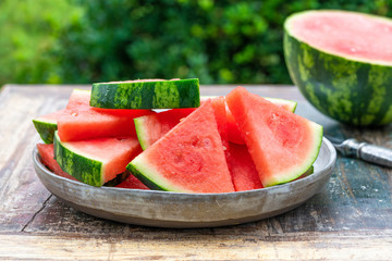 Slices of sweet, refreshing watermelon on a garden table. Summer outdoor eating.