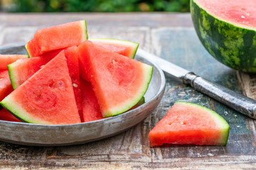 Slices of sweet, refreshing watermelon on a garden table. Summer outdoor eating.