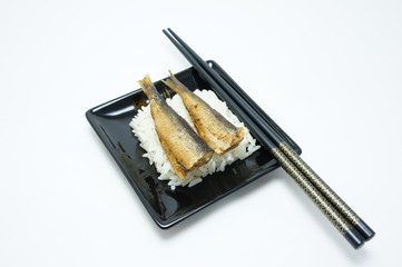 Two fish fried with rice and chopsticks.