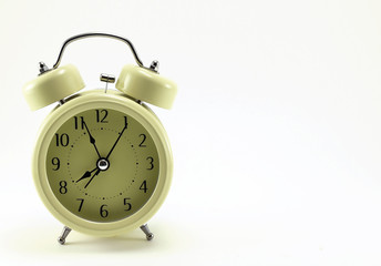 Beige alarm clock, stylized antique with black arrows.