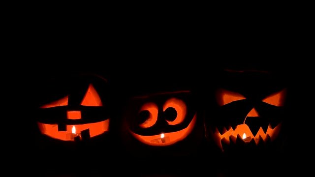 Funny and fearful Halloween pumpkins lightning on dark bakground