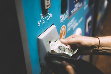 Hand of people purchasing subway tickets through American automated ticket machines at subway...