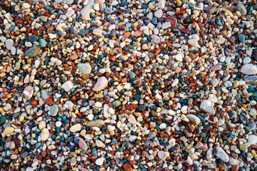 Multicolored sea pebbles on the beach, abstract background