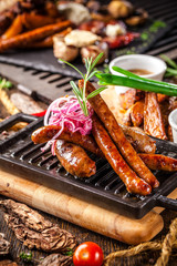 Arabian cuisine in Dubai. Assorted fried sausages on a grill, with sauce, on a wooden board. The concept is a beautiful serve in the restaurant. Background image.
