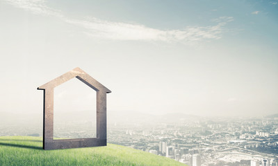 Conceptual image of concrete home sign on hill and natural lands