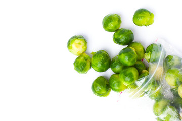 Plastic bag with frozen brussel sprouts isolated on white. Vegetable preservation