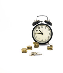 Folded coins next to a retro-alarm clock on a white background, the concept of saving time and money in the future.