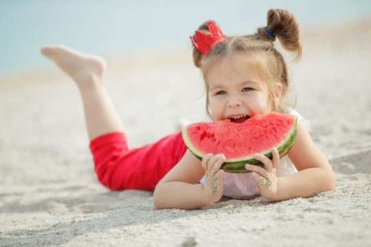 Child with a watermelon at sea
