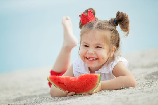 Child with a watermelon at sea
