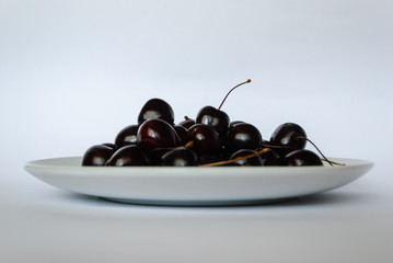 cherry on a plate on a white background