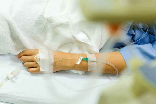 Close up image of IV drip in patient's hand in hospital.