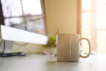 Mug of coffee on office workplace with morning coffee concept.
