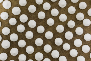 White fresh sweet meringues in large quantities for decorating cakes on a large tray