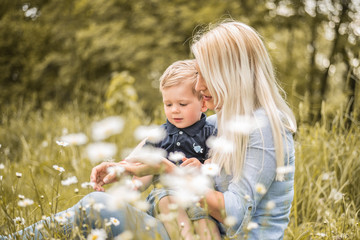 Mutter und Sohn sitzen in der Blumenwiese