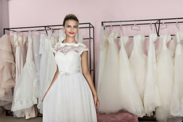 beautiful woman in wedding shop trying on a dress