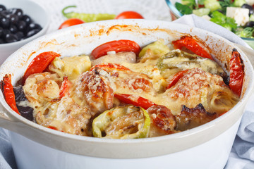 Traditional tasty rustic stew of chicken and vegetables  with Greek salad and black olives