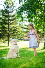 Little girl with golden retriever dog in the park