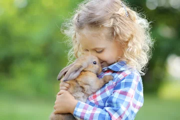 Girl with a cute little rabbit, outdoor, summer day © Natalia Chircova