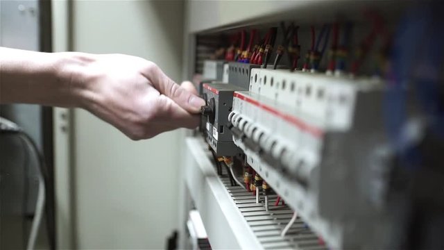The electrician switches on the circuit breakers and starts the system
