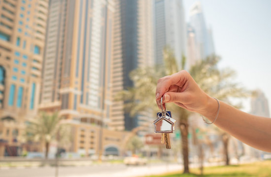 Hand girl holds the keys. The concept of buying an apartment or car in Dubai. Hand close-up.