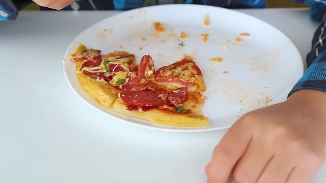 Cute funny child eating pizza with appetite in fast food restaurant. Rel time full hd video footage.