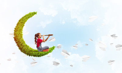 Concept of careless happy childhood with girl on green moon