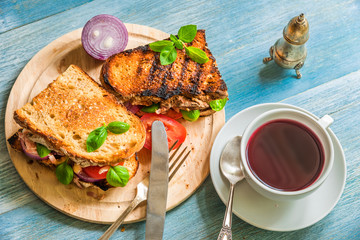 Rustic fast breakfast - toasted toasts with tomatoes and cheese, fruit tea