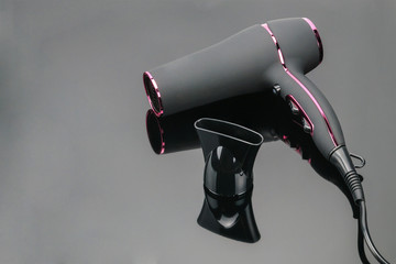 Grey mat hair dryer on the grey mirror background with copy space