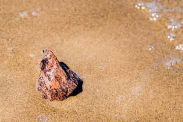 Jasper stone on a sandy beach close up