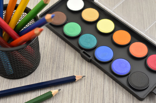 Watercolor tool stock images. Back to school border. Art supplies on a wooden background. School supplies for painting