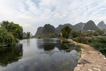 Fototapeta na wymiar Panoramic view of green mountains reflected in still water. Yangshou, China