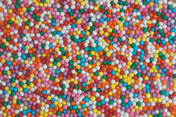 Fototapeta na wymiar Colorful bright background of small balls for screen saver for designer. Multicolored painted grains. Ball Pool Pattern