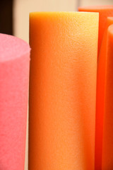 macro shot of one orange pool noodle, pool or therapy or swim noodles in modern colors detail shot