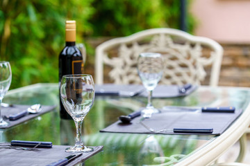 Clean tableware and a bottle of wine on a table