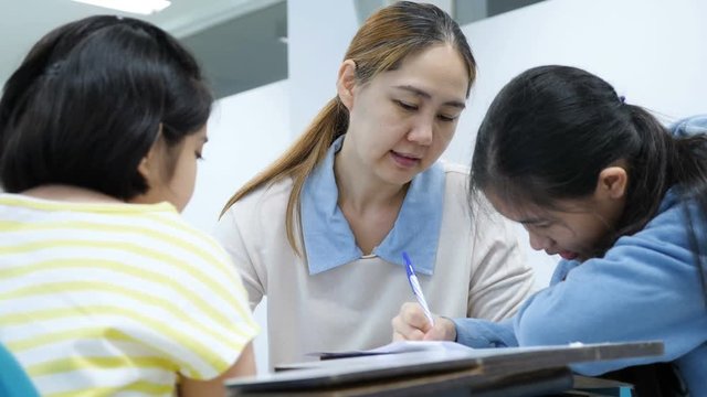4K Happy Asian student girls studying with teacher in classroom