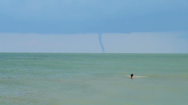 	Tornado on the horizon in the sea.