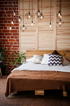 Simple bedroom with double bed, red brick wall and big window