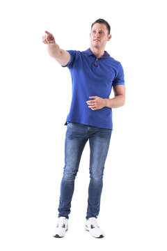 Relaxed Casual Man Showing Way Directions Pointing Finger Away And Looking Up. Full Body Isolated On White Background. 