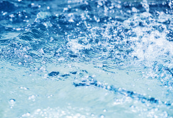 Naklejka na ściany i meble Water splash in swimming pool summer background